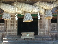A sacred Shimenawa rope, in typical taisha style, over the Rokusho Jinja oratory entrance.