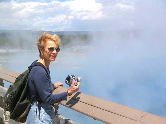 Frontal Barbara with camera before Yellowstone steam pits.