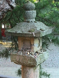 A lantern bestrewn with votive stones.