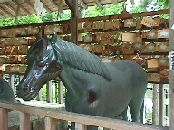 Within the stall: 
  a sculptured horse.